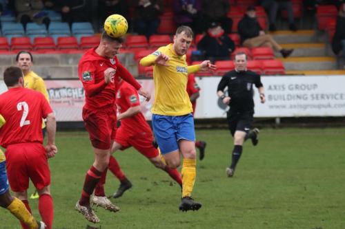 Harrows Adam Richards (red) wins a header against Brad Wadkins