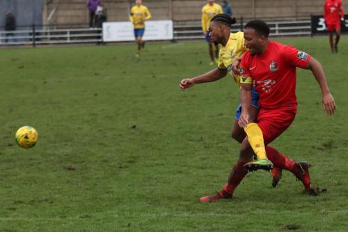 Harrows Shaun Preddie (red) clears from Dernell Wynter