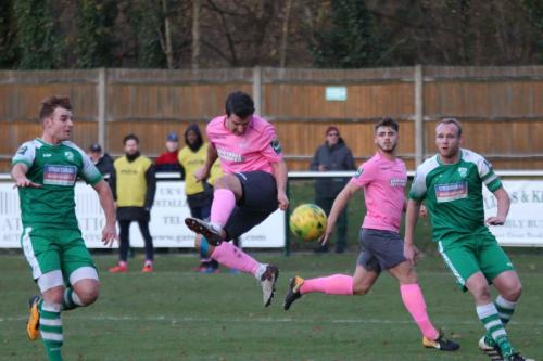 Enfields Elliot Benyon cant quite time his header allowing the keeper to save