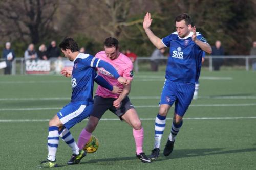 Enfields Matt Johnson tries to get past James Rogers (L) and Liam Friend