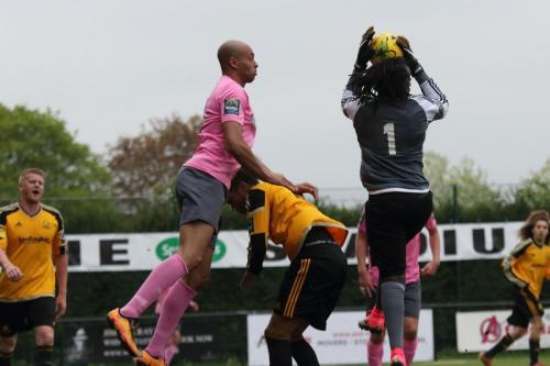 Merstham keeper Ashlee Jones collects a cross ahead of Simon Thomas