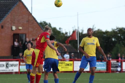 Needhams Kieran Morphew (red) heads clear