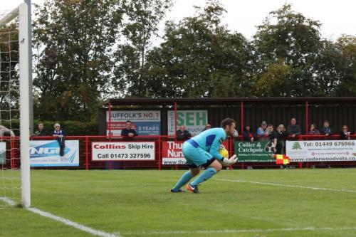 Needhams keeper Danny Gay comfortably saves a shot