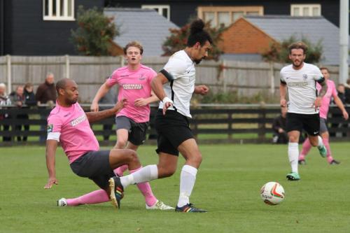 Roystons Adam Murray (white) clears under challenge from Simon Thomas (L)