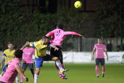 Staines Tommy Brewer (yellow) challenges Ryan Blake