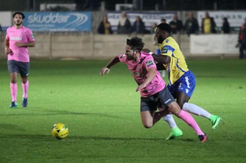 Staines Tyrell Miller-Rodney (R) nudges Drew Roberts in the back to concede a free kick