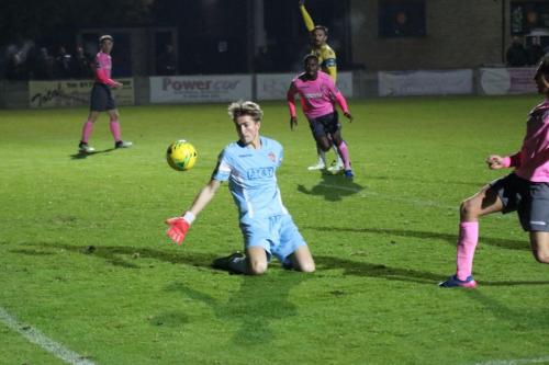 Staines keeper Liam Driscoll is beaten by Sam Youngs, but is reprieved by an offside decision