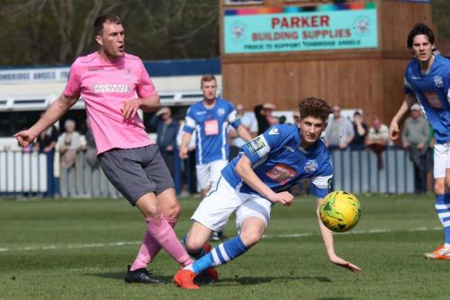 Angels Callum Adonis-Taylor (blue) deflects Brad Wadkins shot for a corner