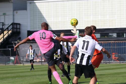 Tooting keeper Kyle Merson gets a fingertip to the ball ahead of Simon Thomas (10)