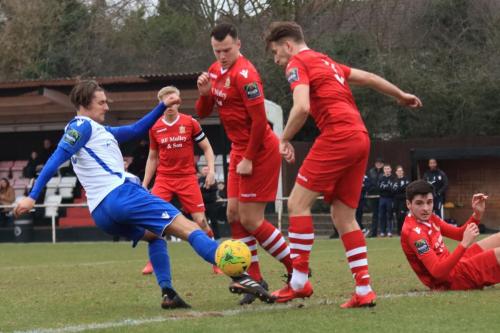 Enfields Sam Youngs (L) shoots against the leg of Remi Sutton (3)