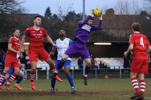 Hornchurch keeper Callum Chafer cuts out a cross to the obvious disappointment of Enfields Kezie Ibe