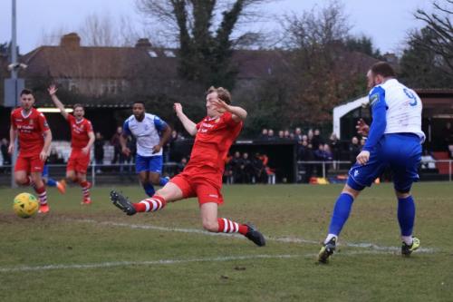 Hornchurchs George Winn (red, R) tries to block a shot from Billy Bricknell (R)