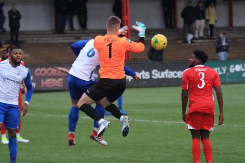 Carshalton keeper Patrick Ohman fumbles under challenge from Dan Rumens