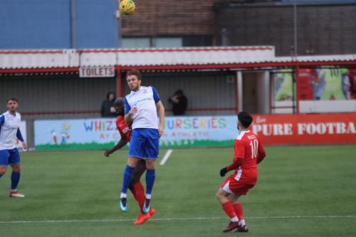 Enfields Remi Sutton (white blue) wins a header