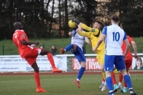 Carshalton keeper Billy Bishop saves from Sam Chaney