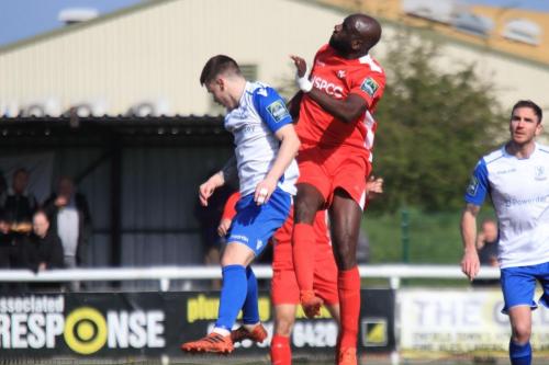 Carshaltons Peter Adeniyi (red) challenegs Sam Chaney