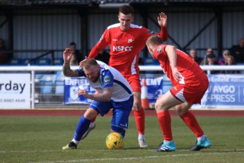 Enfields Billy Bricknell is brought down by Bobby Price (centre)