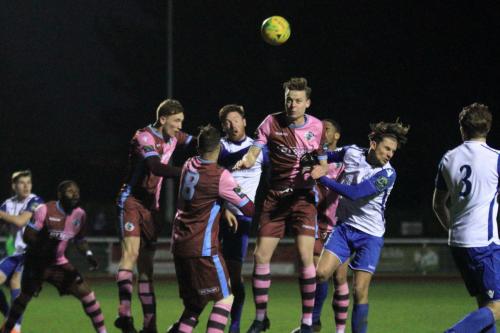 Casuals Jack Strange (brown pink, R) heads clear from an Enfield set piece