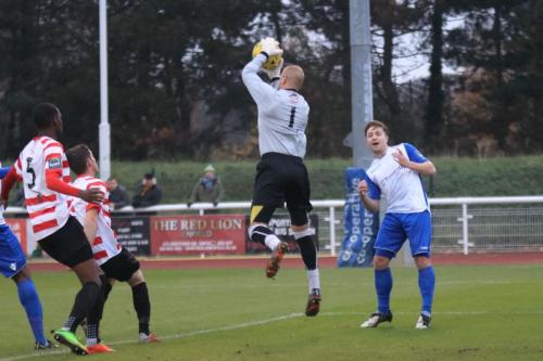Kingstonian keeper Rob Tolfrey collects the ball ahead of Lewis Taaffe (R)