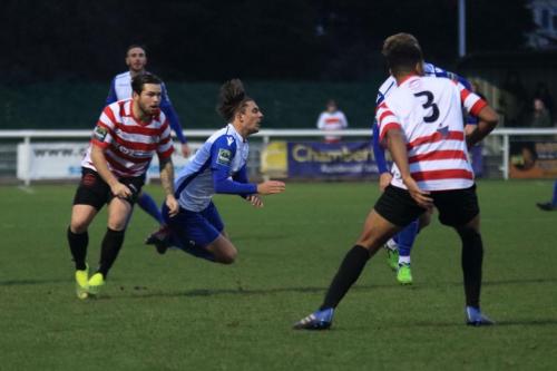 Kingstonians Aaron Lamont (red white) challenges Sam Youngs