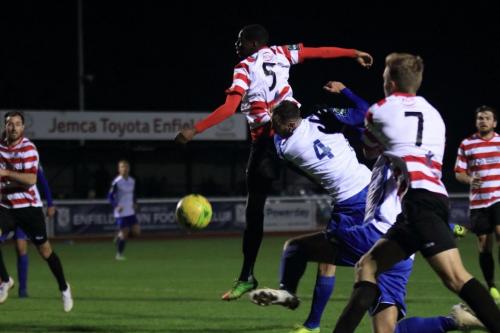 Kingstonians Temi Eweka (5) and Enfields Matt Johnson (4) fail to make contact with a corner