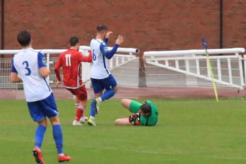 Enfield keeper Matt Nolan dives at the feet of Calum Davies (11) and Dan Rumens