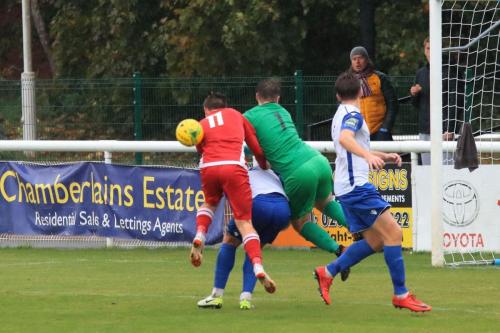 Enfield keeper Matt Nolan finds his route blocked by Dan Rumens and Mersthams Calum Davies (11)