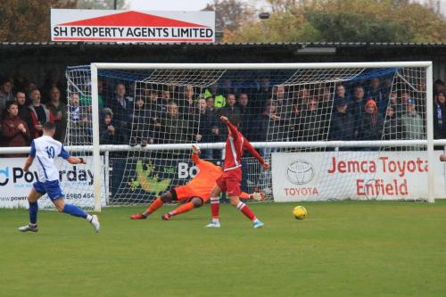 Enfields Brandon Adams (L) rolls the ball past keeper Amadou Tangara but narrowly wide
