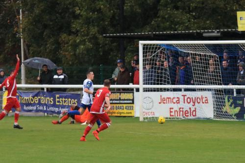 Enfields Brandon Adams (white) watches as the ball rolls agonisingly wide