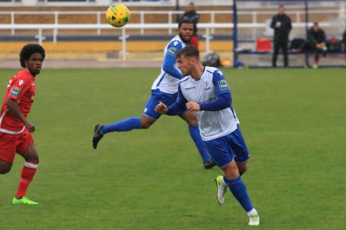 Enfields Dan Rumens heads clear from Walter Figueira