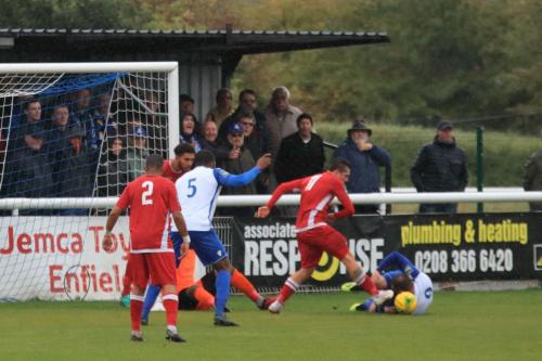 Mersthams Calum Davies (red, R) clears from Billy Bricknell