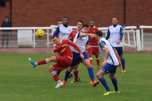 Mersthams Jake Hutchings (red, L) clears