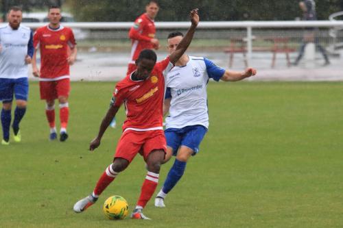 Mersthams Kershaney Samuels clears from Brandon Adams