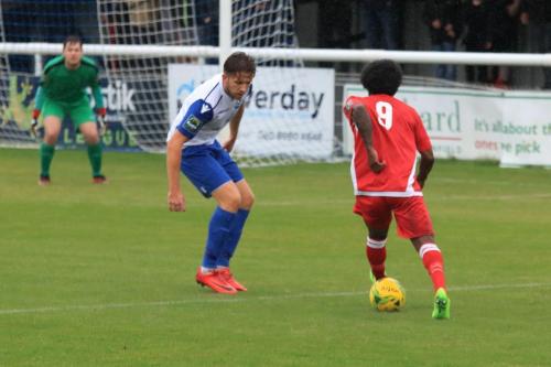 Mersthams Walter Figueira (R) runs at Remi Sutton