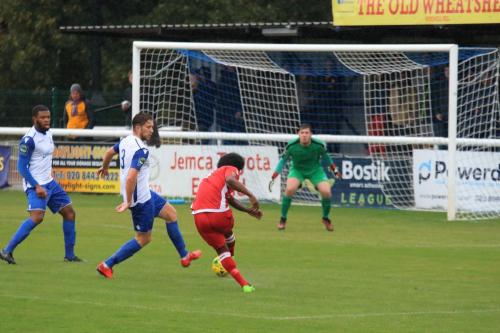 Mersthams Walter Figueira (red) drags a shot wide of the goal