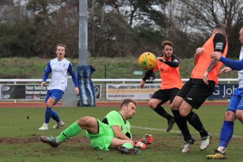 Tonbridge keeper Jonathan Henly diverts a cross into the face of teammate Arthur Lee (orange, R) and out for a corner