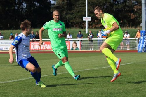 Dorking keeper Slavomir Huk collects ahead of Enfields Lewis Taaffe (L) and teammate  Sami El-Abd