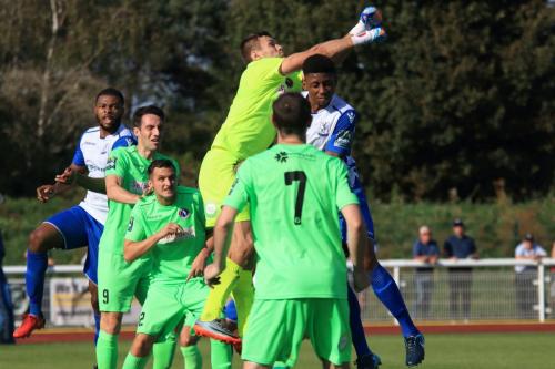 Dorking keeper Slavomir Huk punches clear from Rian McLean