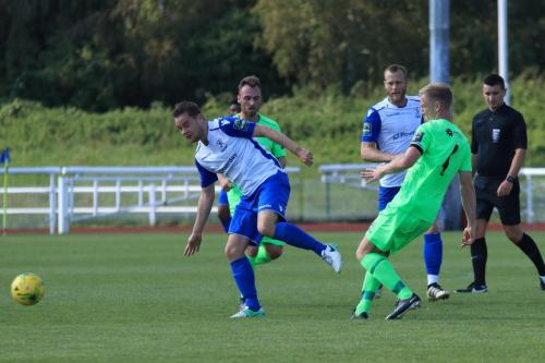Dorkings Chris Boulter (R) clears from Liam Hope