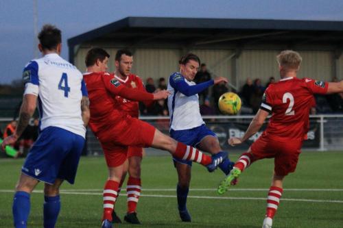 Enfields Sam Youngs tries to curl a shot under pressure from Alex Bentley (2), Glenn Wilson (blue boots) and Kenzer Lee