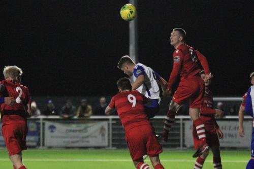 Hornchurchs Jordan Clark (red) heads clear from Dan Rumens