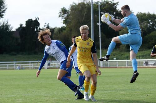 Hornchurch keeper Calum Chafer collects as team mate Alex Bentley shields him from Mickey Parcell