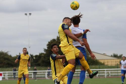 Hornchurchs Nathan Cooper (yellow, R) challenges Sam Youngs