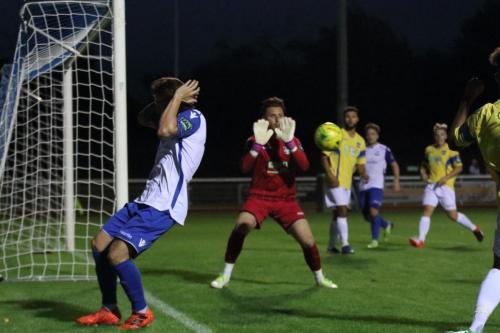 Enfields Sam Chaney (L) protects his head as a shot is fired on goal  Keeper Calum Kitscha blocks it for a corner