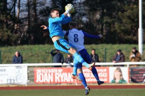 Folkestone keeper Tim Roberts is spun round by the challenge of Ryan Blackman but holds onto the ball