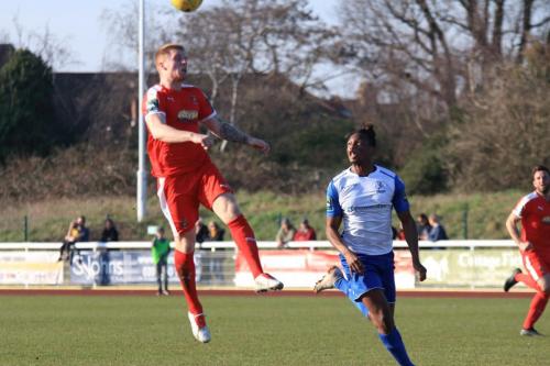 Folkestones Finn OMara (L) heads back to his keeper as Karl Oliyide hopes for an error