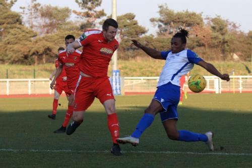 Folkestones Josh Vincent (L) clears from Karl Oliyide