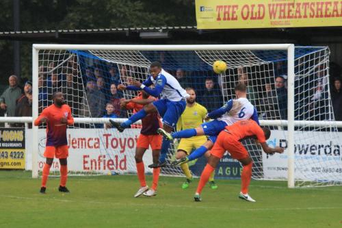 Enfields Taofiq Olomowewe (White, L) and Dan Rumens challenge at a corner kick