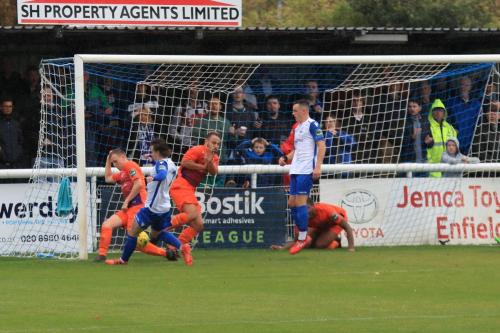 Wares Billy Baird (orange, L) and Louis Rose combine to prevent Sam Chaney from scoring