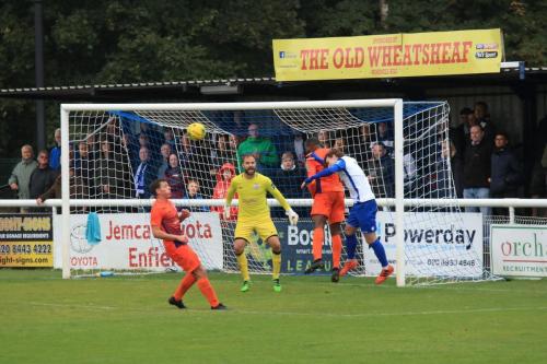 Wares Dom Njoya (orange, R) heads clear from Sam Chaney